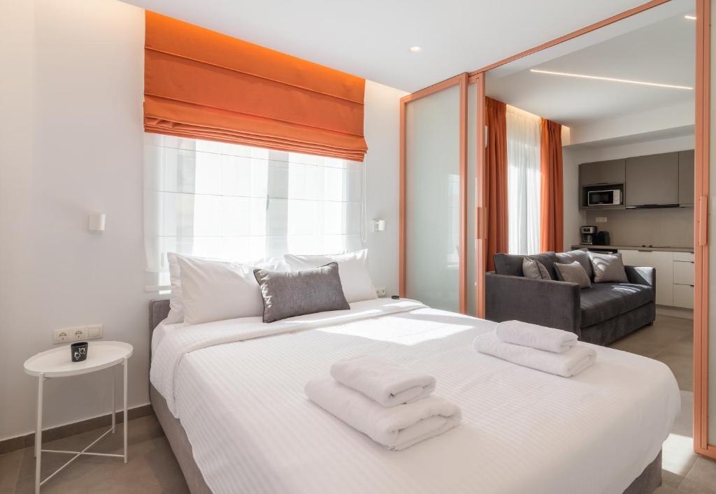 a bedroom with a large white bed with towels on it at Athens Theatrou Apartments in Athens