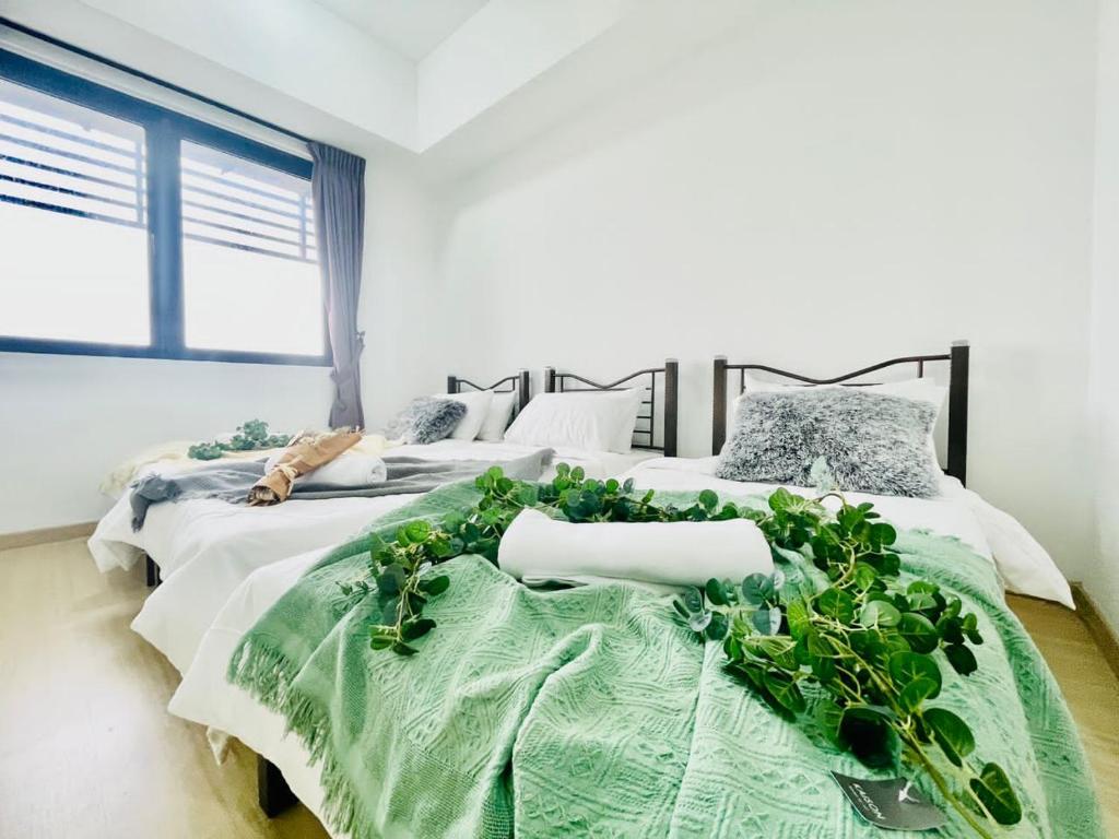 twee bedden met planten in een slaapkamer bij Kota Damansara 3BR for 1-12pax near IVF in Encorp in Petaling Jaya