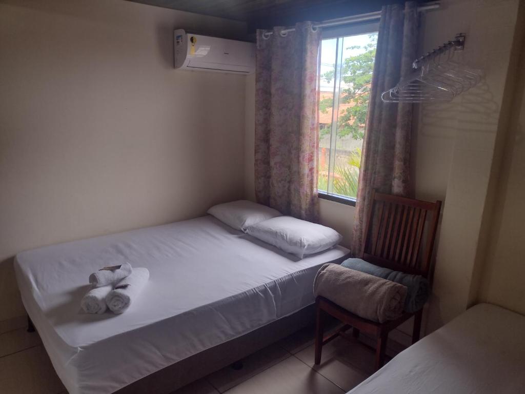 ein kleines Schlafzimmer mit einem Bett und einem Fenster in der Unterkunft Pousada Mar e Sol in Saquarema