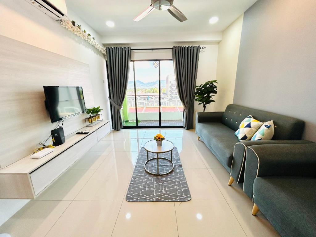 a living room with a couch and a tv at P3 Cozy Stay / Waterpark / 7-8pax Ipoh in Ipoh