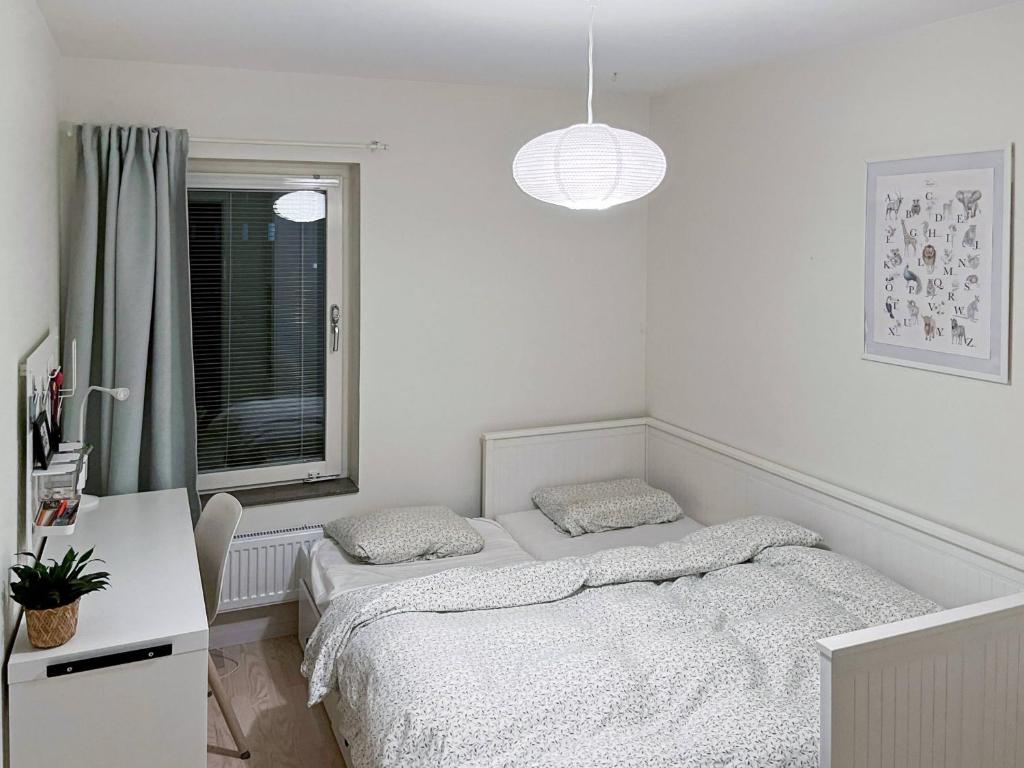 a white bedroom with two beds and a desk at Room in Guest room - Room - 5 Min Walk Eurovision Hyllie in Malmö