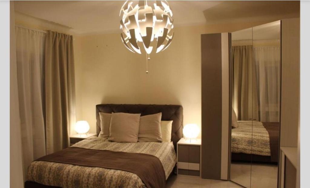 a bedroom with a bed and a chandelier at Appartamento Lungo Il Canale - Via Trento - 6 persone in Trieste
