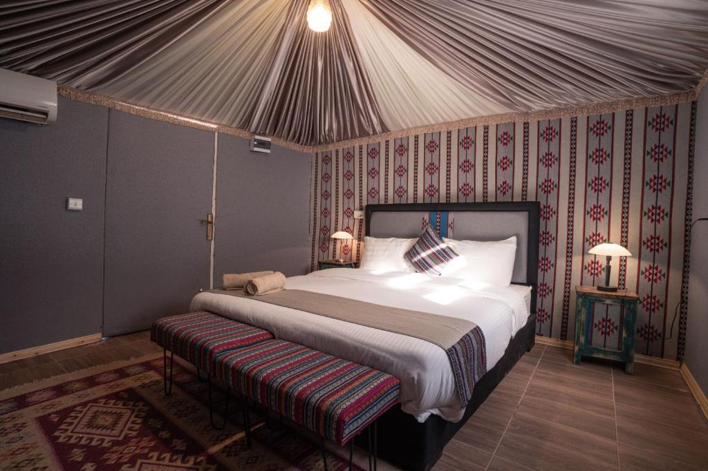 ein Schlafzimmer mit einem großen Bett in einem Zelt in der Unterkunft Rahayeb Desert Camp in Wadi Rum