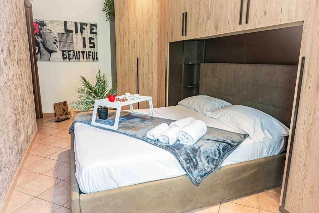 Una cama grande con una bandeja de toallas. en Appartamento comodo alla metro ideale per coppie e famiglie, casa costa en Collegno