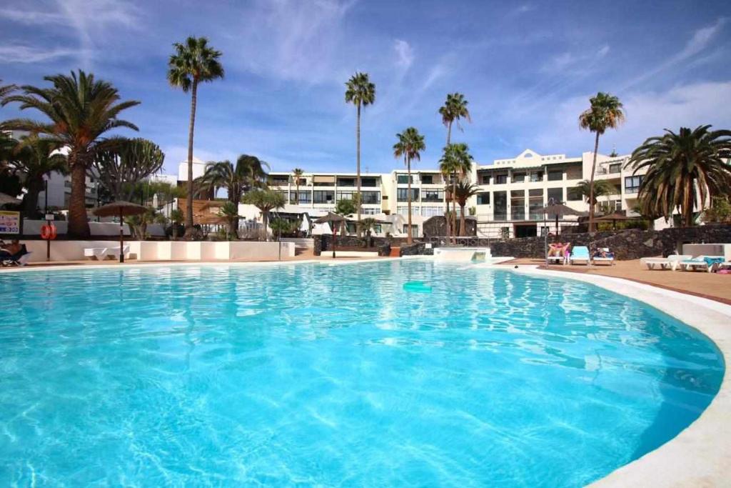een groot blauw zwembad voor een hotel bij Blue Sand Apartment in Costa Teguise in Costa Teguise