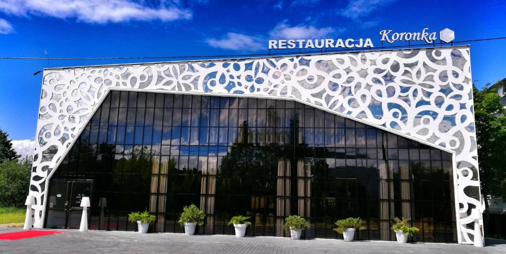 a building with potted plants in front of it at Hotel Ramka & Restaurant & Wine Bar in Poznań