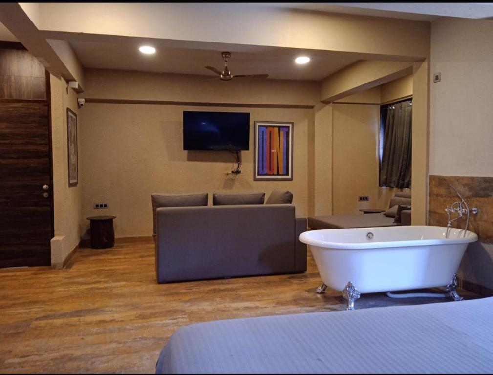 a large room with a bath tub and a tv at Celebrations - Vagator - Goa in Vagator