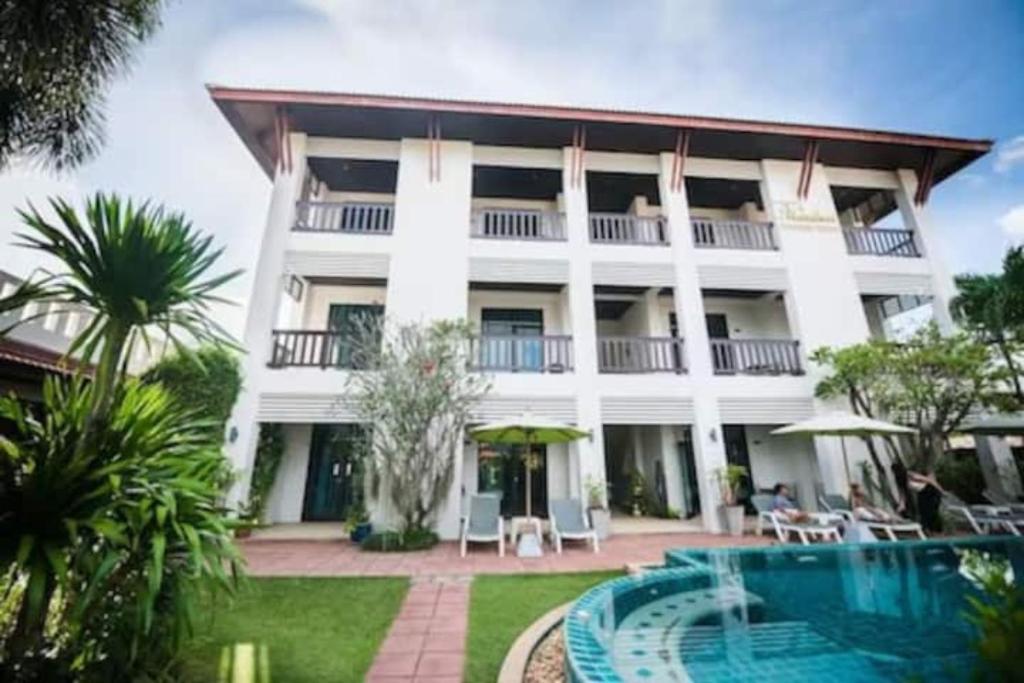 un gran edificio blanco con una piscina frente a él en Monaburi Boutique Resort, en Rawai Beach