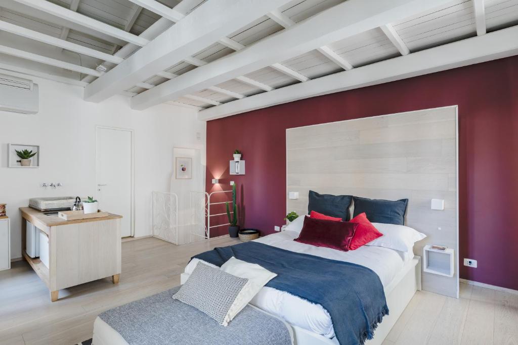 a bedroom with a large bed and a red wall at La Casetta a Monti in Rome