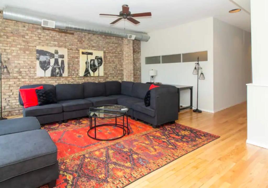 a living room with a black couch and a red rug at Elegant 3 Bed One Bath At West Side in New York