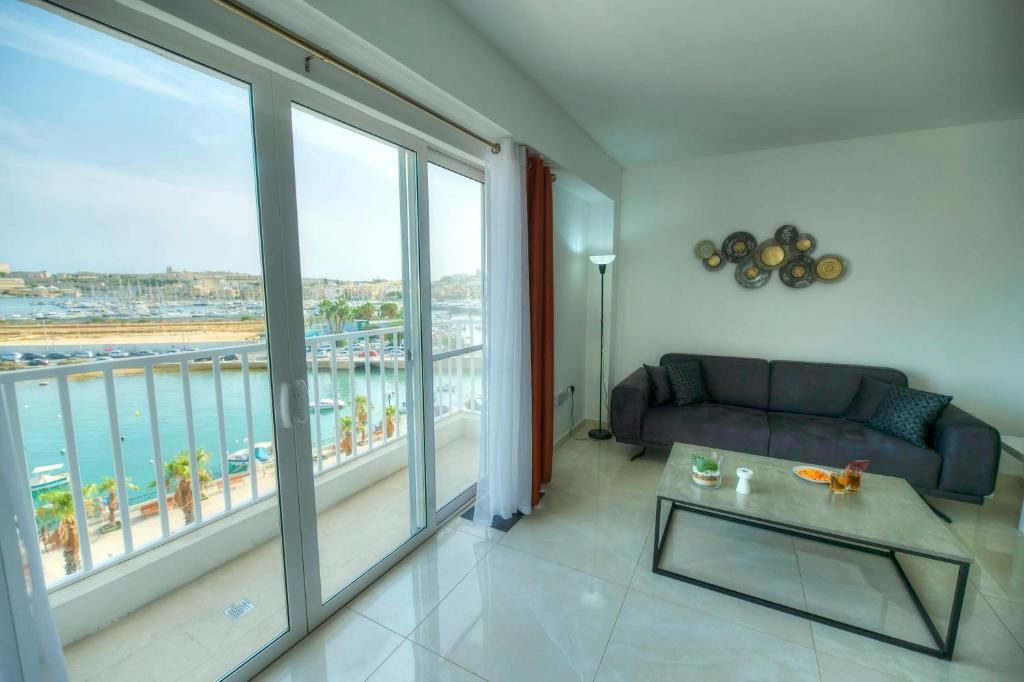 a living room with a couch and a large window at Bright & modern 2bedrooms with sea views GOGZR1-2 in Il-Gżira