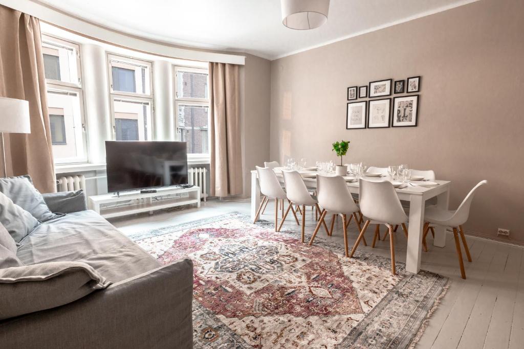 sala de estar con mesa de comedor y sillas en 2ndhomes Bright & Spacious, 5 Bedroom Apartment in the Center en Helsinki