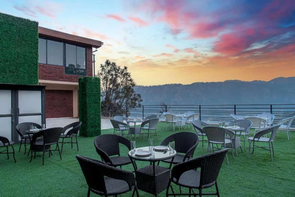 eine Gruppe von Tischen und Stühlen, die auf dem Gras sitzen in der Unterkunft Kasauli dream hills in Kasauli