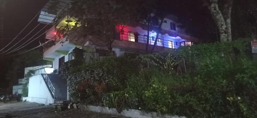 a house with red and blue lights on it at night at Sugan Residency in Kodaikānāl