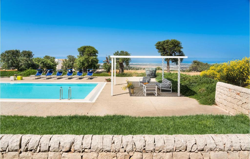 uma piscina com cadeiras e uma mesa junto ao oceano em 3 Bedroom Awesome Home In Ragusa em Ragusa