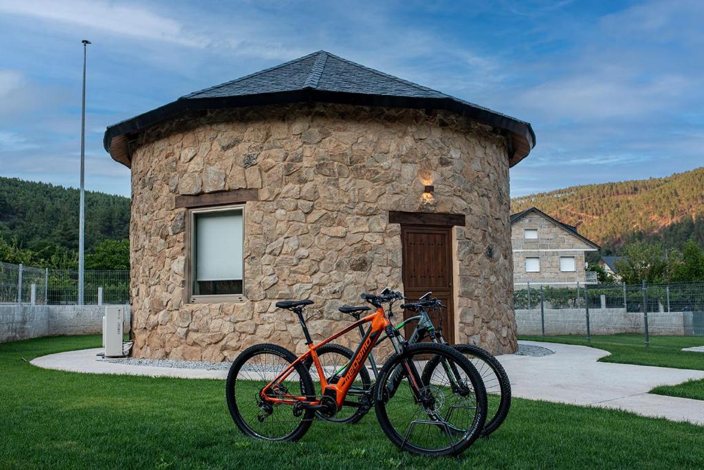dos bicicletas estacionadas frente a un edificio de piedra en Pallozas Turisticas Ridicodias - A Pedra, 