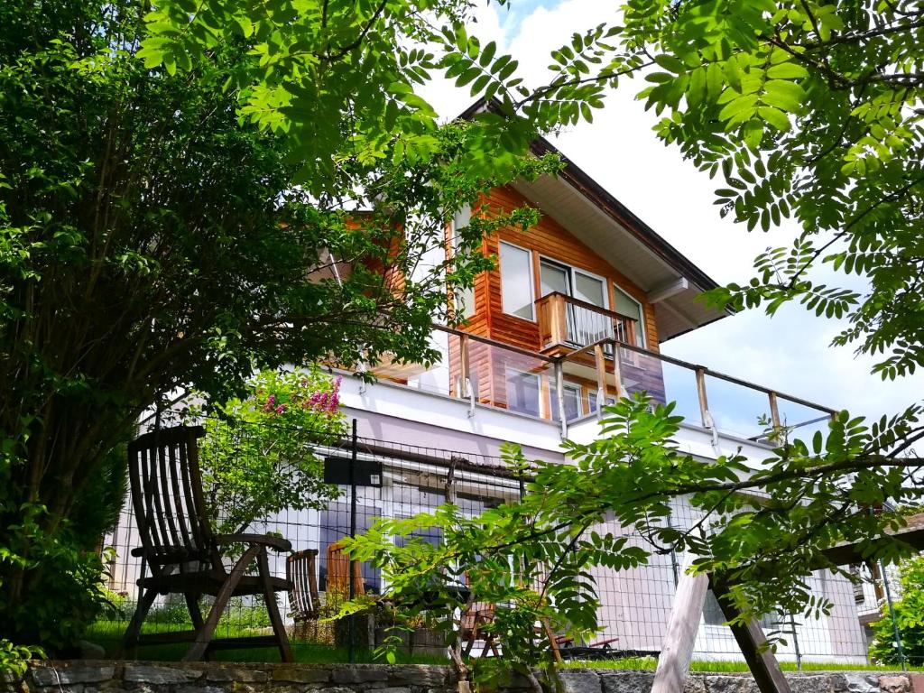 a wooden chair sitting in front of a house at Ferienwohnung HÖLLWART - exclusiv, ruhige Lage, Panoramablick in Bischofshofen