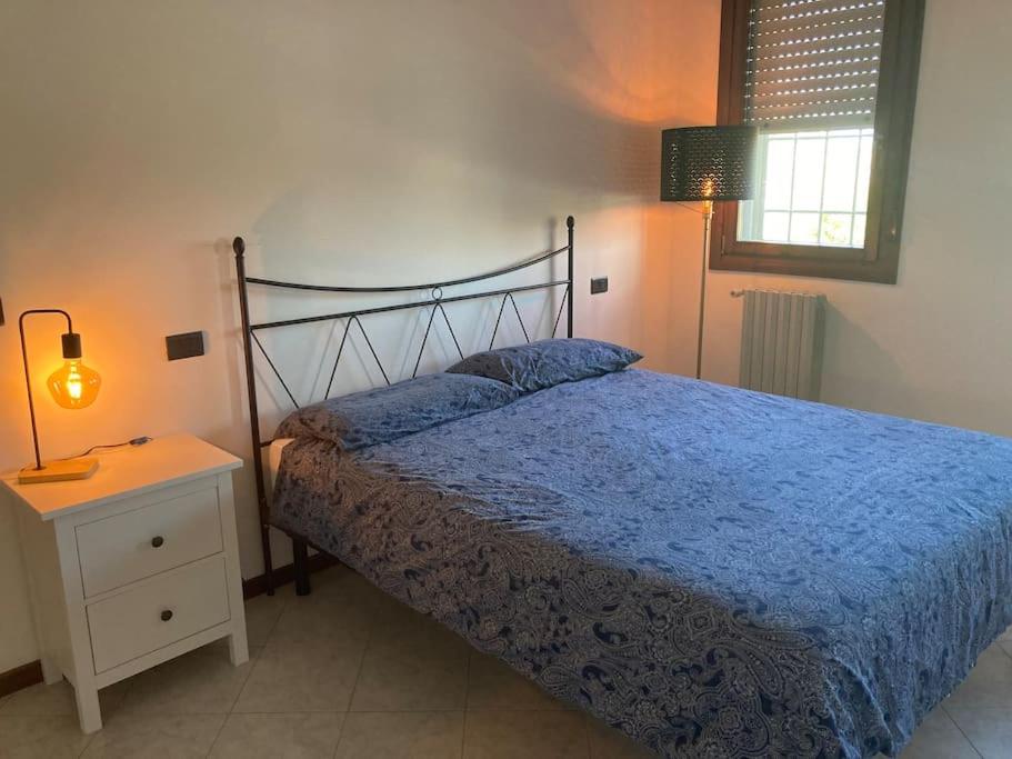 a bedroom with a bed with a blue comforter and a lamp at Civico 14 a Bologna in Castel Maggiore