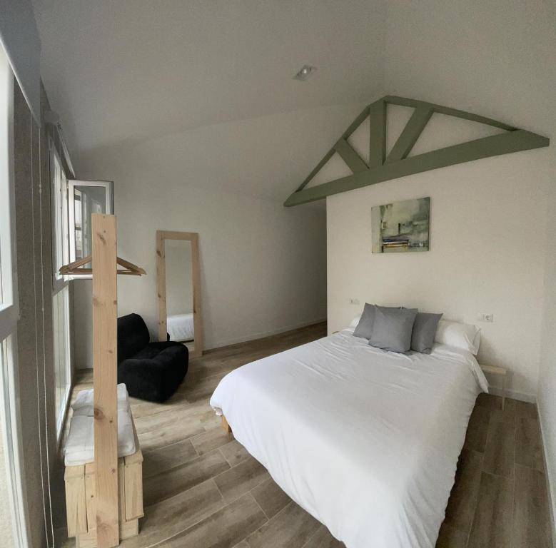 una camera con un grande letto bianco di Casa Arco a Pontevedra