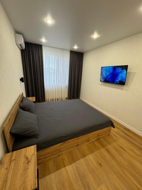 a bedroom with a large bed and a window at Люкс Апартаменты White Pearl на Подолье in Vinnytsya
