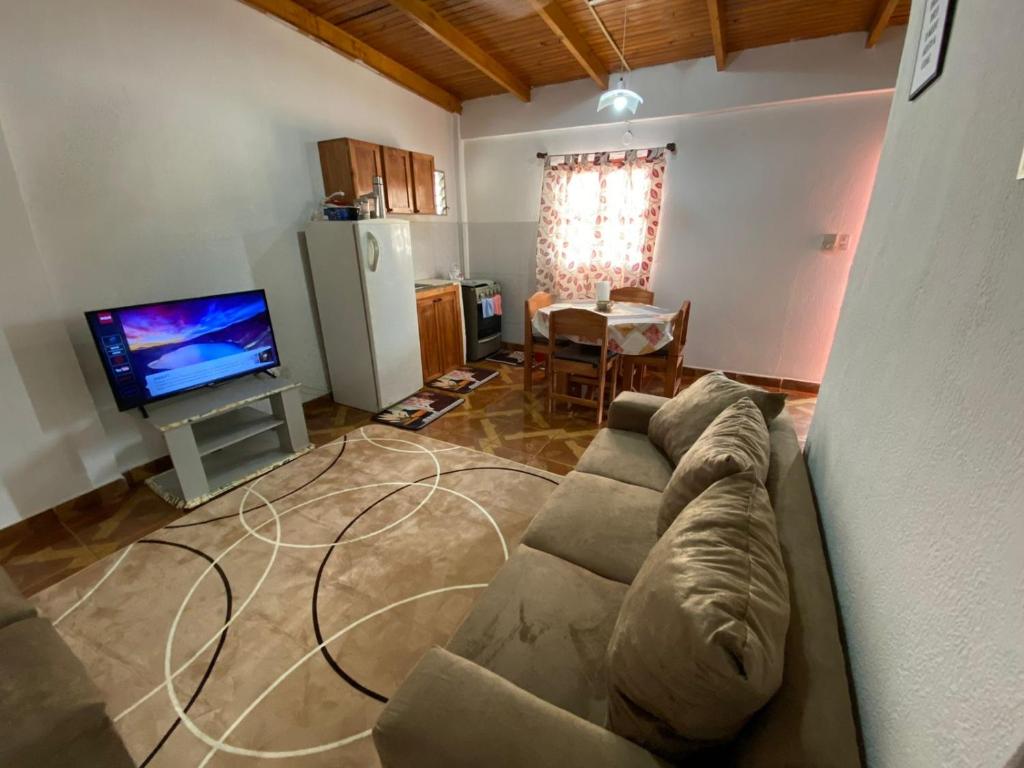 un soggiorno con divano e TV a schermo piatto di Leosan departamento a Puerto Iguazú
