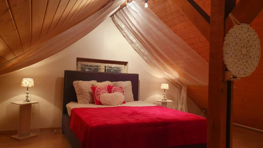 a bedroom with a red bed with two lamps at 2 Zimmer in Kestenholz in Kestenholz