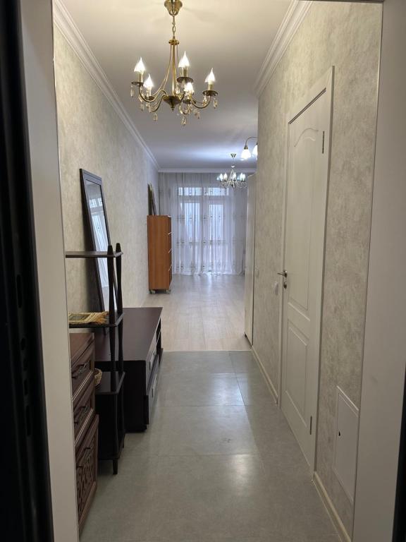 un corridoio con scala e lampadario pendente di однокомнатная квартира a Prigorodnyy