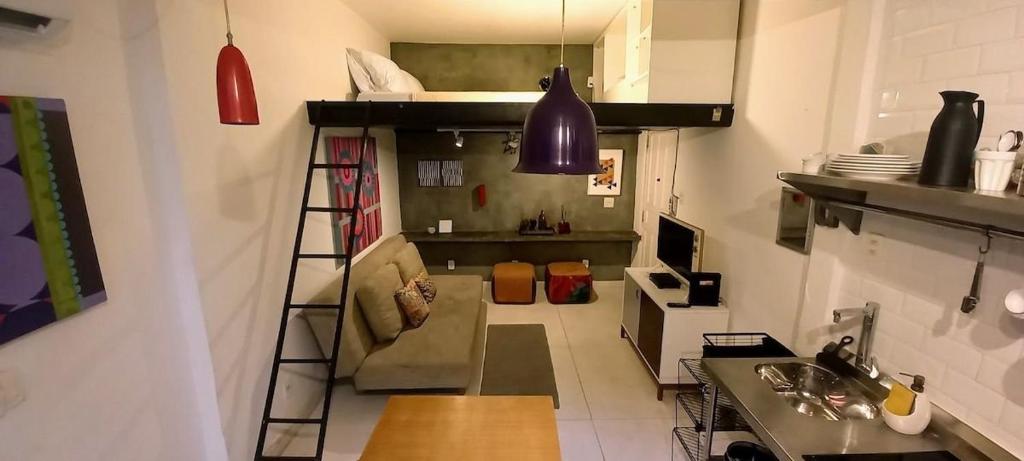 Habitación pequeña con cama elevada y cocina en Charmoso studio na Urca próximo ao Pão de Açúcar, en Río de Janeiro