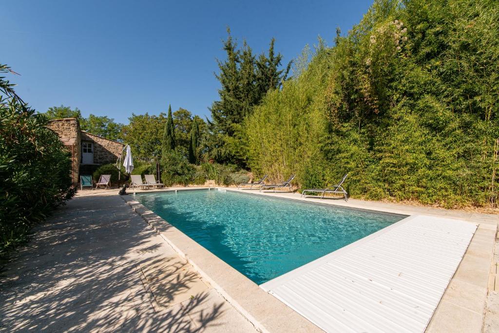 uma piscina num quintal ao lado de uma casa em Mas Titourin - Moulin du 18ème entièrement rénové em Ansouis