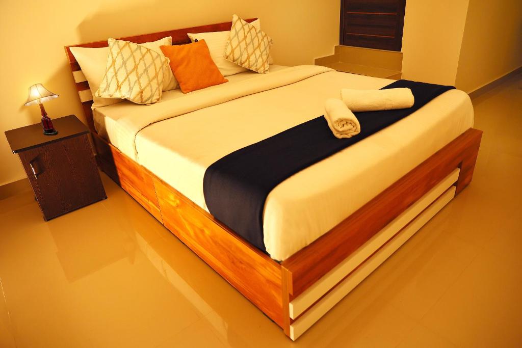 a bedroom with a large bed with a wooden frame at LOYAL RESIDENCY in Sultan Bathery