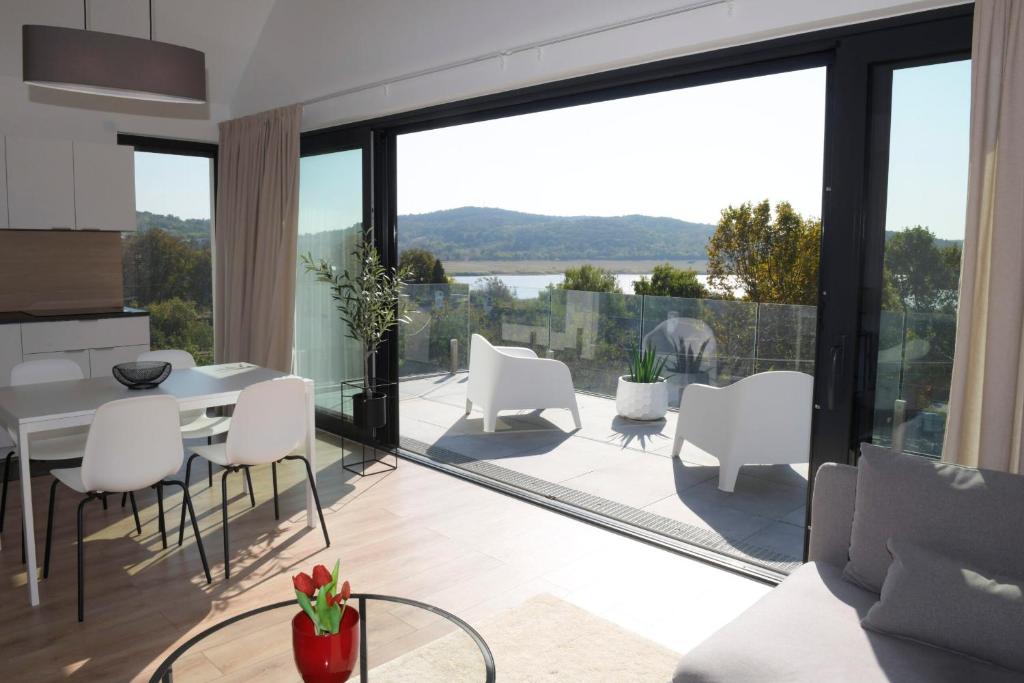 a living room with a table and white chairs at Major Residence in Tihany