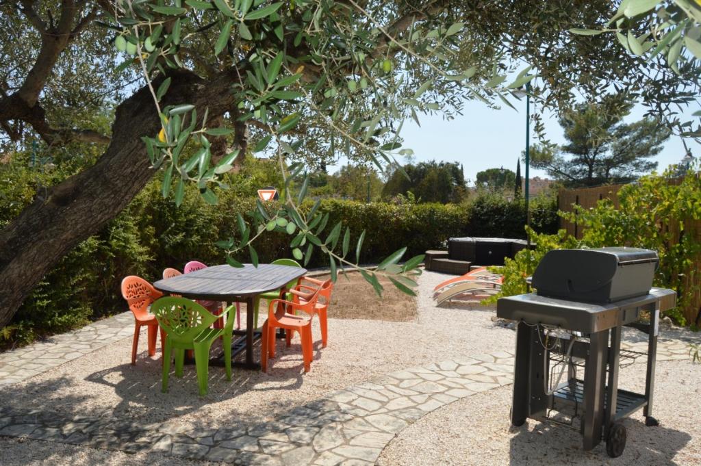 una mesa con sillas y una parrilla en el jardín en Villa Rose, en Le Muy