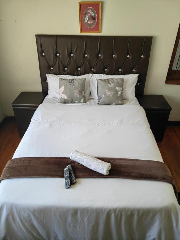 a bed with two remote controls on top of it at Fairfield Guest House in Pietermaritzburg