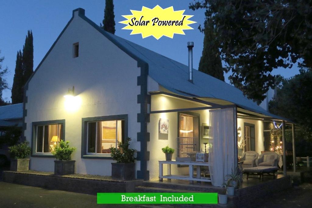 una casa blanca con un cartel que diga energía solar en Zeekoegat Country House BñB, en Vosburg
