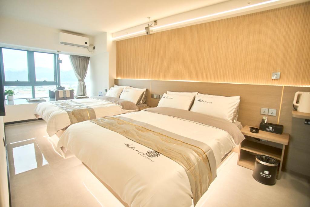 a hotel room with two beds and a window at South Wind Blowing Dreams B&B - Xiamen North Railway Station in Xiamen