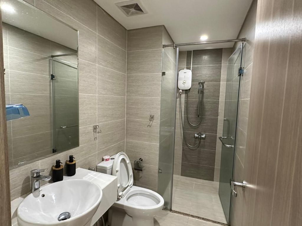 a bathroom with a shower and a toilet and a sink at An Nhiên Vinhome Grand Park 0425 in Ho Chi Minh City