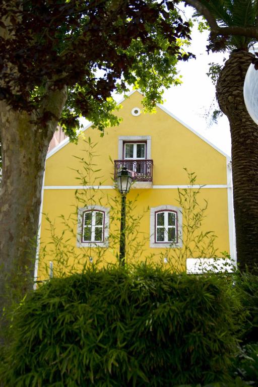a yellow building with a balcony on the side of it at Casa da Fonte - Holiday Apartments in Cascais