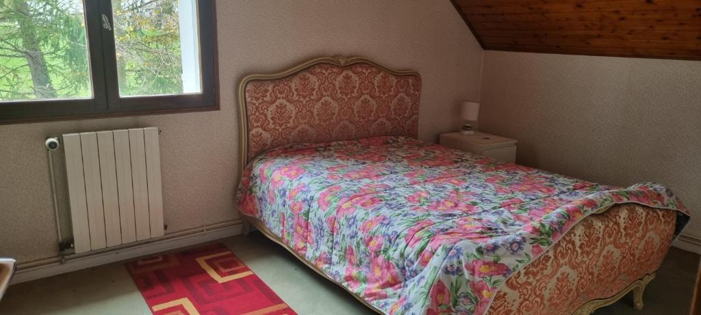 1 Schlafzimmer mit einem Bett mit Blumenbettdecke in der Unterkunft Location chambre dans villa in Villers-Robert