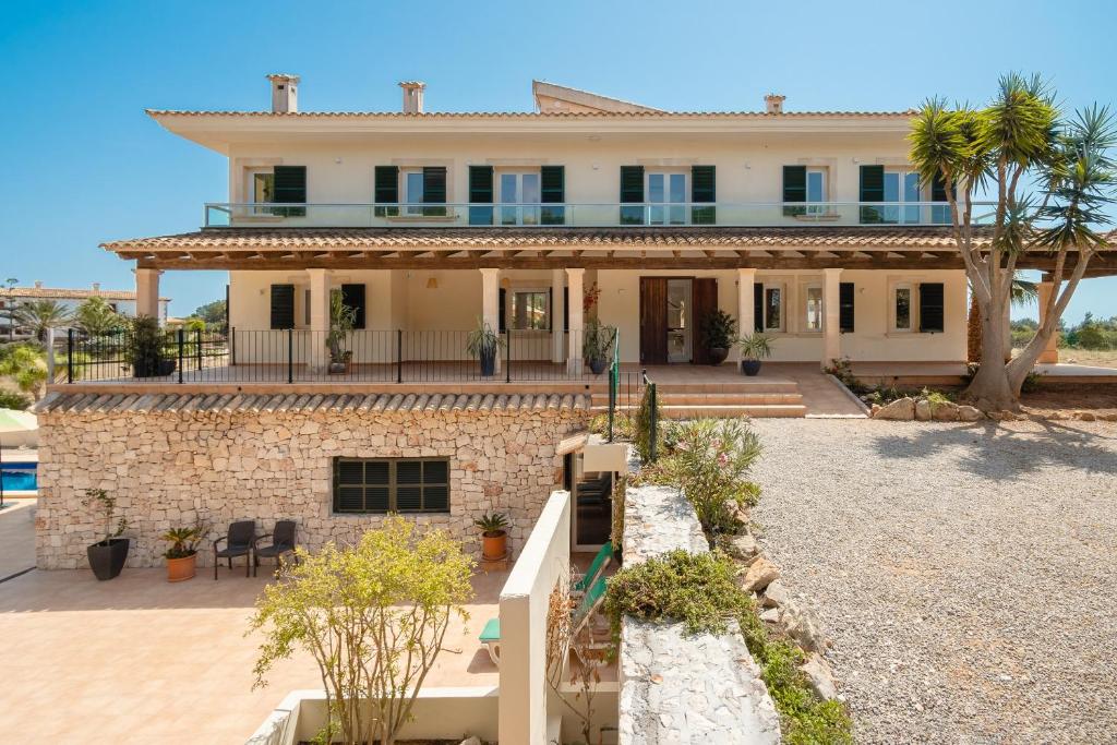 ein großes Steinhaus mit einer Palme in der Unterkunft Villa Salinas de Mallorca in Colonia Sant Jordi