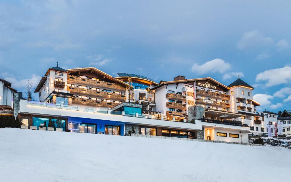 eine Gruppe von Gebäuden auf einem verschneiten Hügel in der Unterkunft Wellnesshotel Cervosa in Serfaus