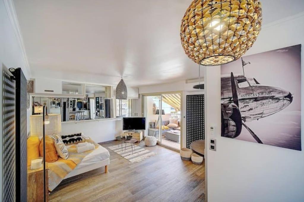 - un salon avec un canapé et un lustre dans l'établissement Beautiful 28m2 studio with balcony, à Cannes