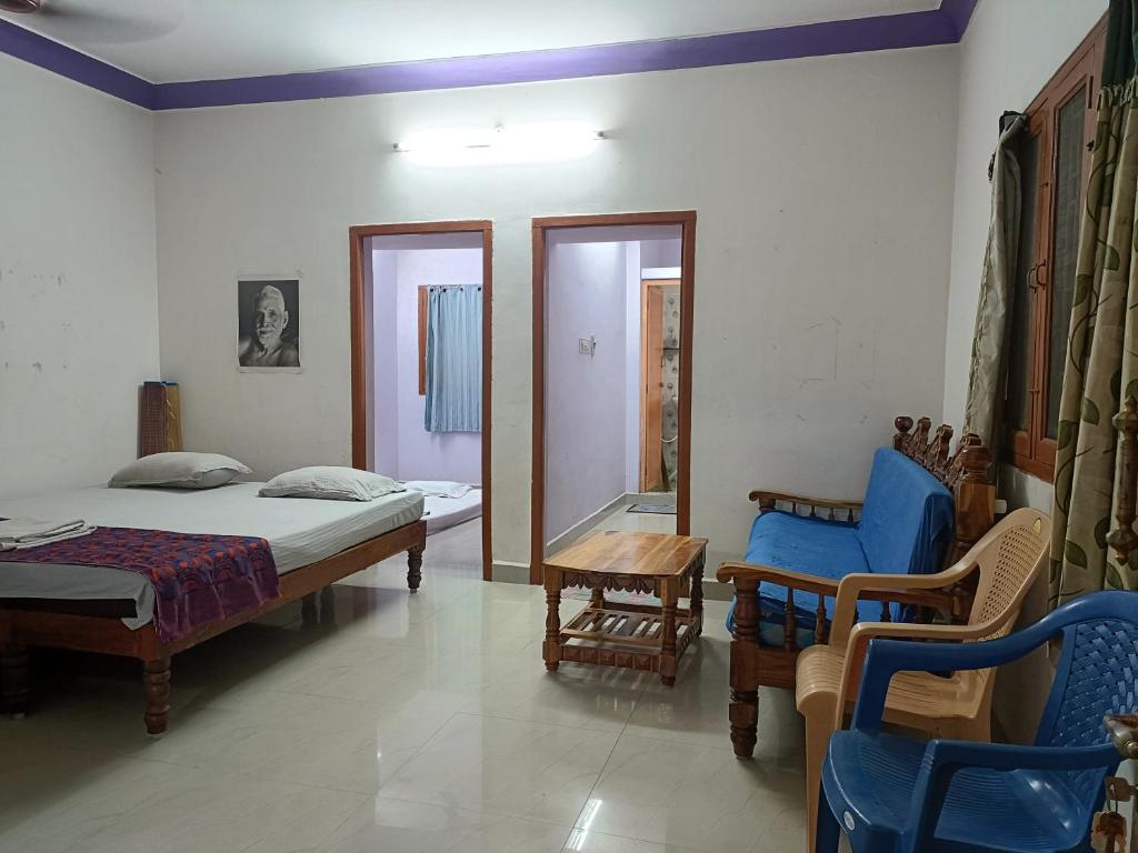 a bedroom with a bed and a table and chairs at Full Moon House Tiruvannamalai in Tiruvannāmalai