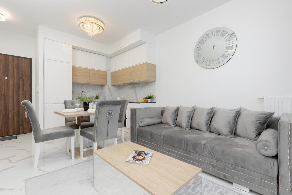 un soggiorno con divano e tavolo di Warsaw Sarmacka Apartment with Gym, Sauna and Parking by Renters a Varsavia