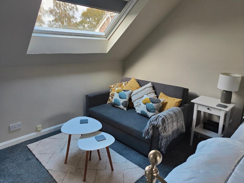 a living room with a couch and a window at Self contained annexe in pretty Suffolk village in Bury Saint Edmunds