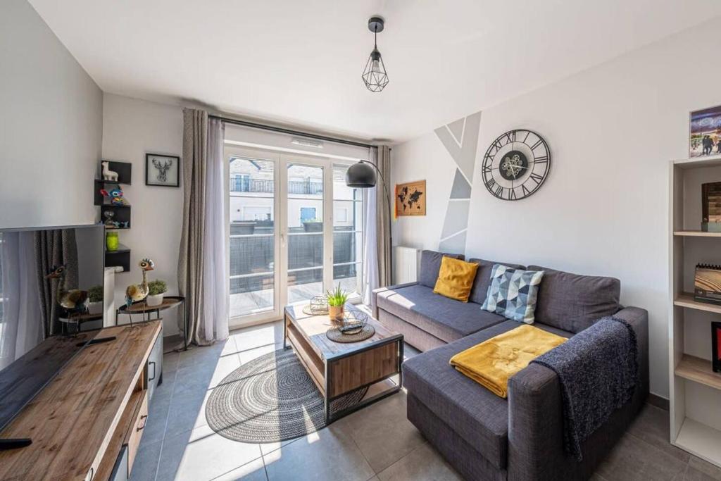 un salon avec un canapé et une table dans l'établissement F2 Cozy Pour 4 Proche Disneyland - Fairytale Factory, à Villeneuve-Saint-Denis