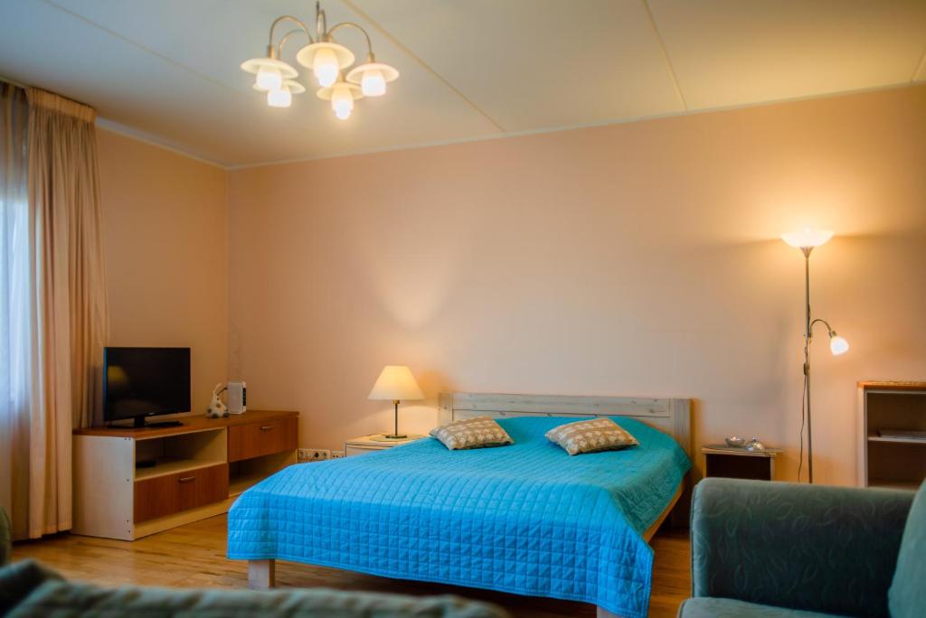 1 dormitorio con 1 cama azul y TV en Romeo Family Kaarli Apartment, en Tallin