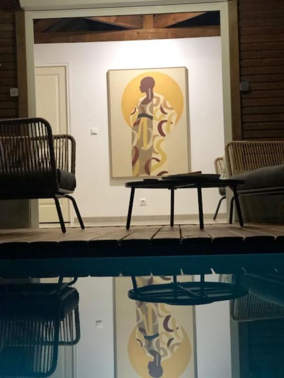 a table and two chairs and a painting on a wall at Villa Tigo T3 Colibri in Sainte-Luce