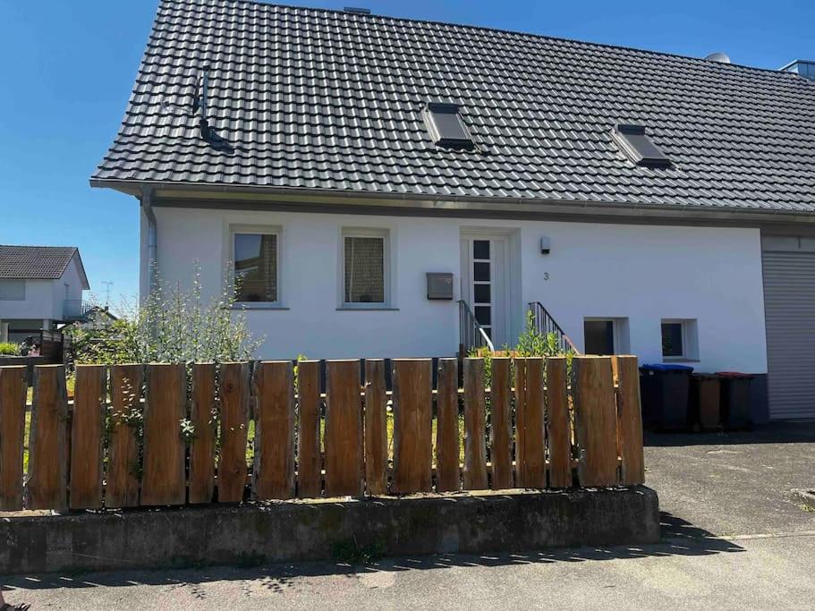 uma casa branca com uma cerca de madeira em frente em Franzis Landhaus em Singen