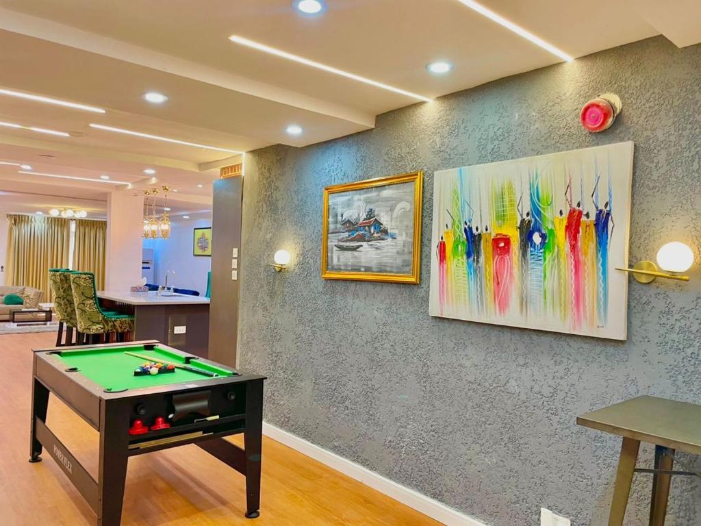 a room with a pool table and paintings on a wall at WATERFRONT 3BR APT W/FREE PARKIN WiFi NETFLIX POOL in Lagos