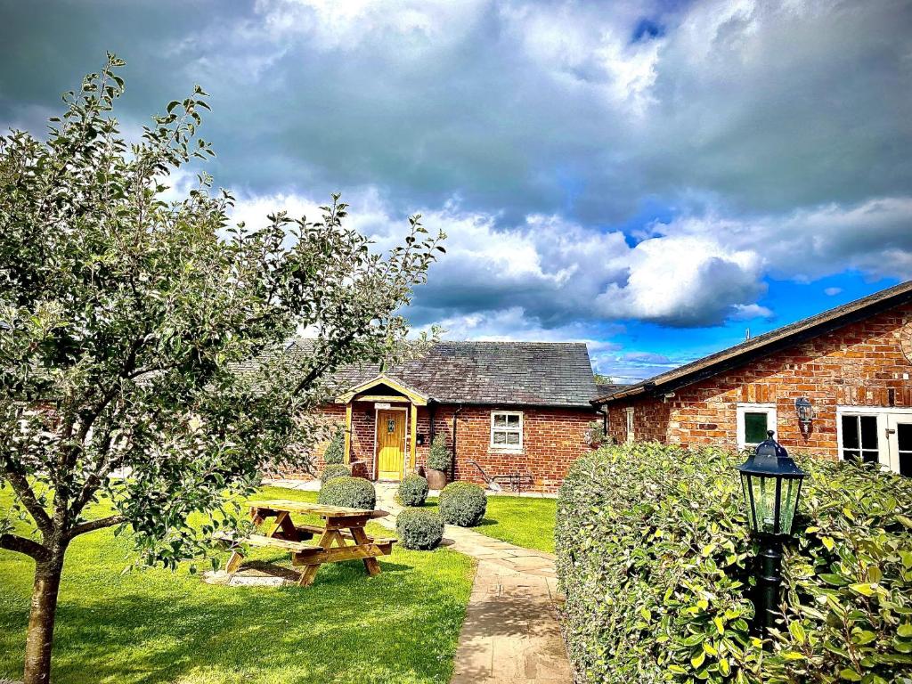 a brick house with a picnic table in the yard at New Farm Cheshire B&B in Winsford